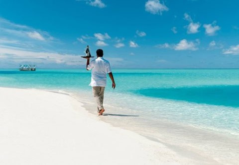 Butler-Service am Strand mit Blick auf das türkisfarbene Meer.