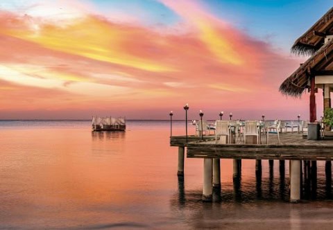 Restaurantterrasse über dem Wasser bei Sonnenuntergang.