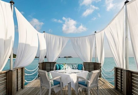 Privates Dinner-Pavillon über dem Wasser mit weißen Vorhängen.