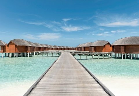 Holzsteg zu den Overwater-Villen über der türkisfarbenen Lagune.