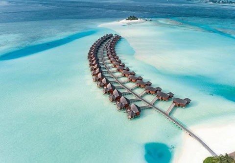 Luftaufnahme der geschwungenen Wasserbungalows im Anantara Dhigu Maldives Resort.