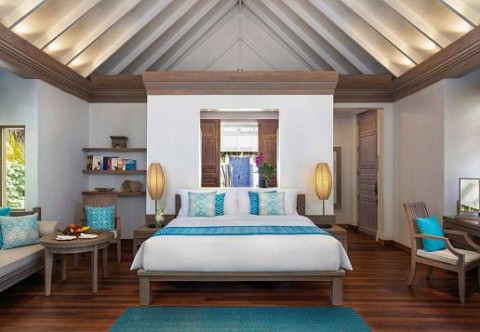 Großzügiges Schlafzimmer mit Holzboden und tropischem Design.