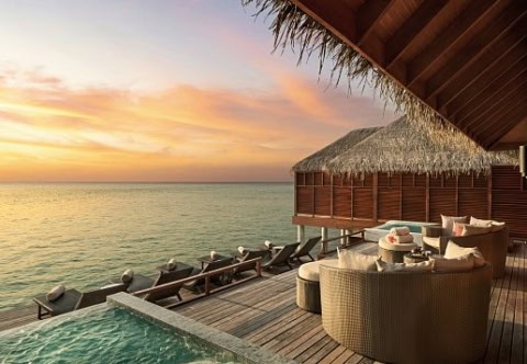 Overwater-Villa mit privater Terrasse bei Sonnenuntergang im Anantara Dhigu.