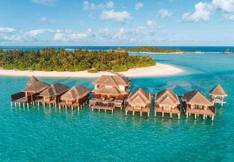 Wasserbungalows auf Stelzen in der türkisfarbenen Lagune.