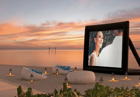 Open-Air-Kino am Strand bei Sonnenuntergang.