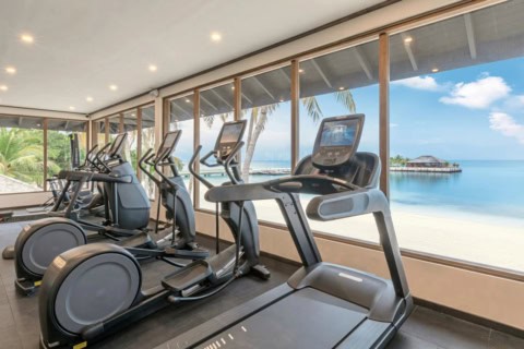 Fitnessraum im Jawakara Islands Maldives mit Meerblick und modernen Trainingsgeräten