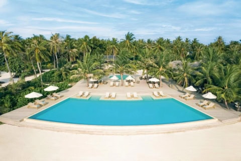 Poolanlage des Jawakara Islands Maldives mit großem Infinity-Pool direkt am weißen Sandstrand