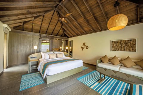 Moderne Beach Villa im Jawakara Islands Maldives mit großem Bett und tropischem Interieur