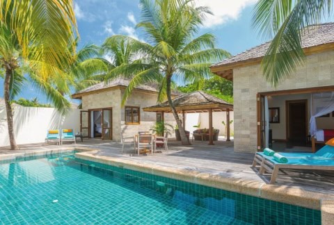 Großer Privatpool mit mehreren Villen im tropischen Garten.