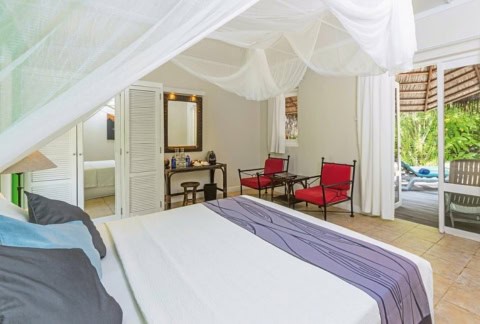 Helles Schlafzimmer mit Himmelbett in einer Sangu Water Villa.