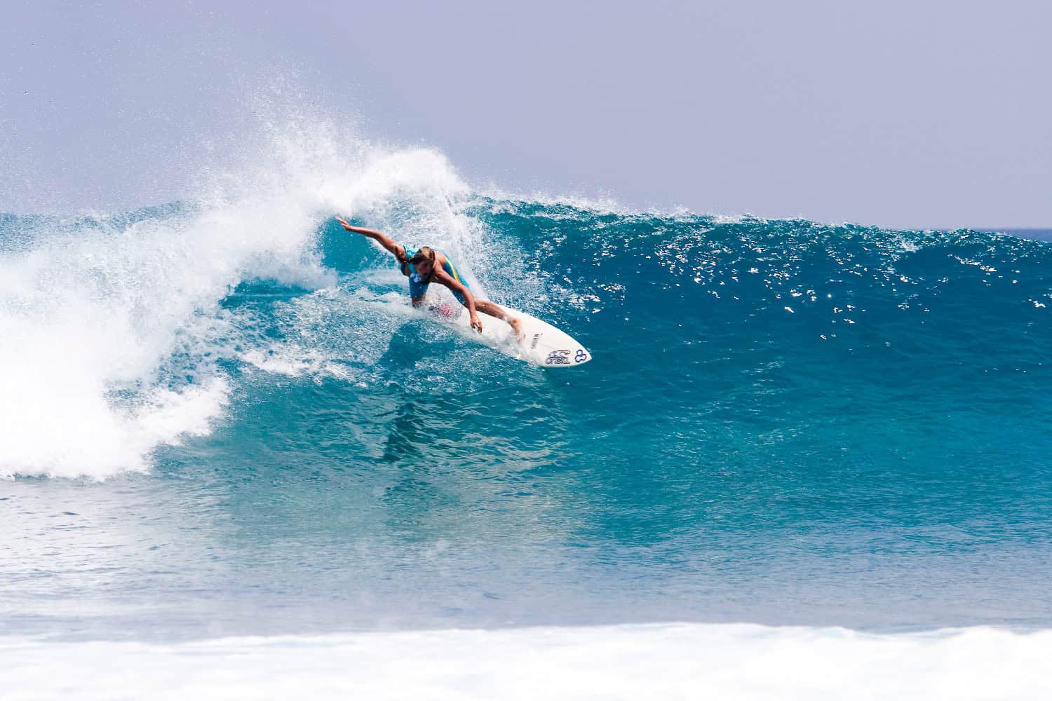 Surfer reitet Welle im Indischen Ozean bei den Malediven, dynamische Bewegung und klares Wasser
