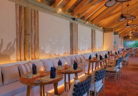 Hotelrestaurant direkt am Strand, lange Sofawand mit Zweiertischen