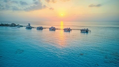 Overwater Hideaway Villa im Soneva Secret bei Sonnenuntergang mit Blick über den Indischen Ozean