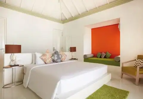 Elegantes Schlafzimmer mit farbiger Sitznische im Sun Siyam Olhuveli.