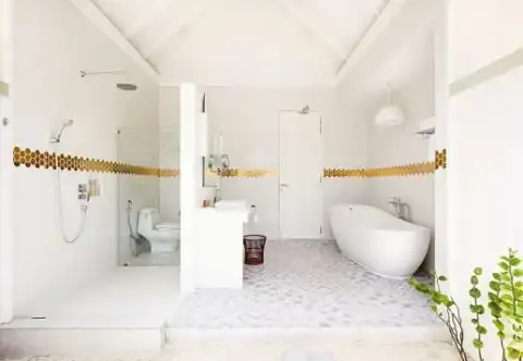 Modernes, offenes Badezimmer mit Regendusche und freistehender Badewanne in einer Villa im Sun Siyam Olhuveli.